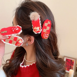 Détail de barrettes à cheveux en peluche rouge avec broderie et bords en dentelle