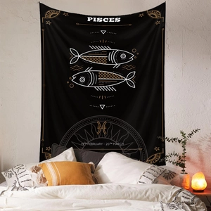 Detail of Pisces zodiac tapestry with gold embroidery on black fabric in a bedroom