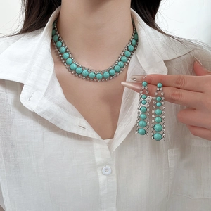 Détail d'un ensemble de bijoux bohème avec perles en résine turquoise et strass brillants
