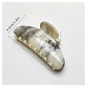 Detail view of large marble texture hair claw clip showing precise size and dimensions