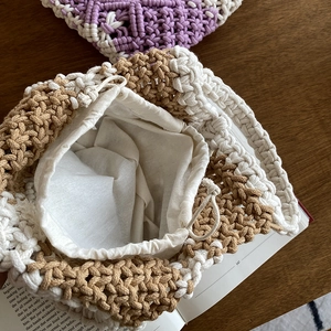 Close-up of handmade crochet bag with beige cotton rope weave and drawstring liner