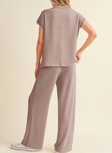 Back view of a mauve ribbed knit two-piece lounge set with short sleeve top and wide leg pants
