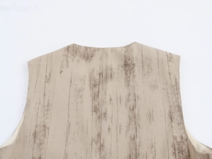 Dettaglio del top smanicato beige con trama a venature del legno verticale e tessuto di qualità