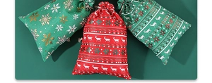 Macro detail of Christmas burlap drawstring gift bags with snowflake and reindeer patterns