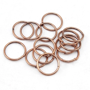 Macro detail of bronze DIY open jump rings for jewelry making on white background
