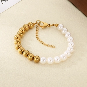 Detail of gold metal beads and white pearls spliced on a steel chain with lobster clasp