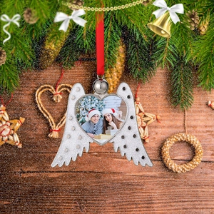 Detailed view of heart frame ornament with angel wings and rhinestones on wood background