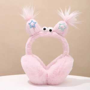 Close-up of pink plush ear muffs with monster eyes and colorful star details