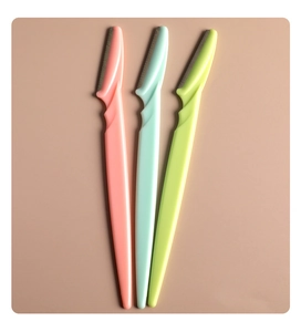 Close-up of three colorful stainless steel eyebrow razors in pink, mint, and lime green