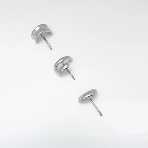 Macro shot of three polished silver minimalist geometric stud earrings in diverse shapes