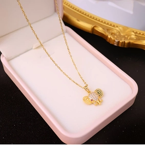 Golden elephant pendant necklace with colorful gems in a pink jewelry gift box