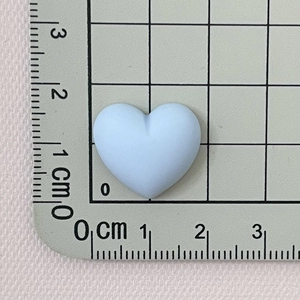 Detailed size measurement of light blue matte resin heart charm against a centimeter ruler