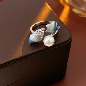 Detail of seashell and starfish open ring with blue enamel and pearl on leather