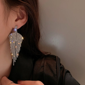 Macro view of silver tassel earrings with leaf design and sparkling rhinestones
