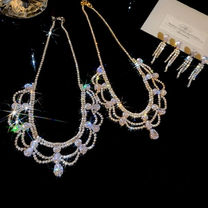 Dettaglio macro della collana con frange di cristallo multistrato e orecchini d'argento