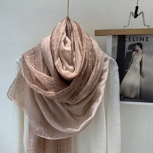 Detail of soft lotus pink linen scarf featuring exquisite lace trim and airy texture