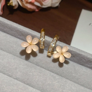 Macro view of champagne gold floral earrings with cat-eye petals and pavé-set diamonds