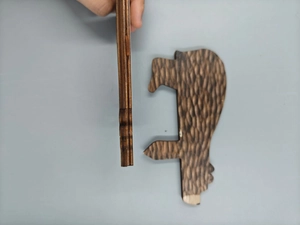 Macro shot of two brown bear wooden door stoppers showing grain texture and thickness