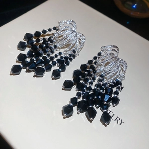 Detail of silver tassel earrings with black crystal beads and textured metal finish