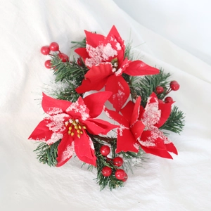 Close-up of red poinsettia flowers with pine needles and snowy finish for Christmas decor