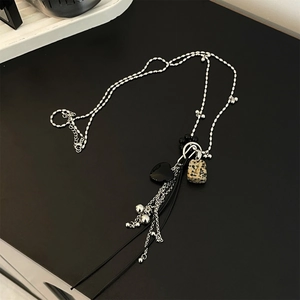 Detailed macro view of the alloy chain with black heart and marbled square stone charms