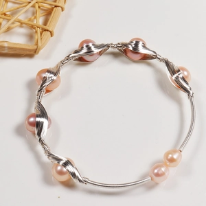 Close-up of handmade freshwater pearl wire-wrapped bracelet with pink pearls and silver wire