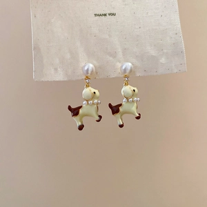 Detail showing cartoon dog charm earrings with white pearls and sparkling zircons