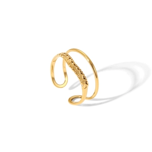 Close-up of golden double-layer open ring featuring minimalist textured dot design