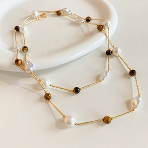 Detail of double-layer necklace with brown tiger eye stones and baroque pearls