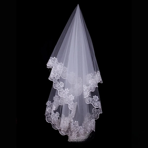 Close-up of white bridal veil featuring intricate floral lace embroidery on sheer mesh fabric