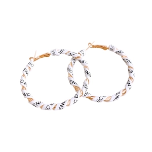Golden round earrings with white leather wrap featuring black letter prints on white background