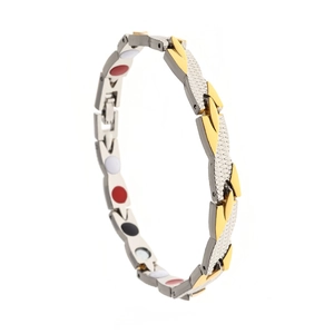 Detail of bicolored magnetic health bracelet with inlaid stones and textured finish