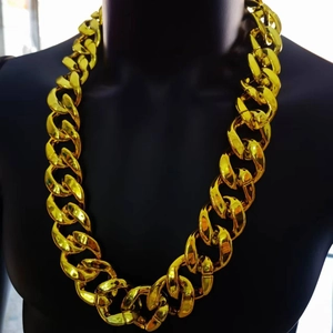 Close-up of thick gold-tone Cuban link necklace displayed on a black mannequin