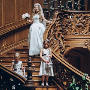 Elegant white off-shoulder satin bridal gown with ball gown skirt and matching flower girl dresses