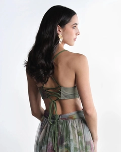 Detail of green criss-cross tie-back top and floral mesh skirt back view on a model