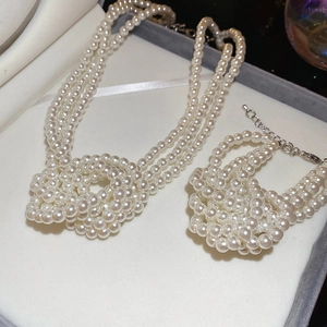 Detailed view of French vintage triple-layer knotted pearl necklace and bracelet set in a gift box