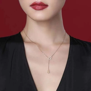 Detailed close-up of a hollow gold gourd pendant necklace with pavé-set crystals on model