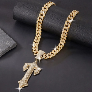 Macro shot of gold hip hop Cuban chain with a large rhinestone-encrusted cross pendant
