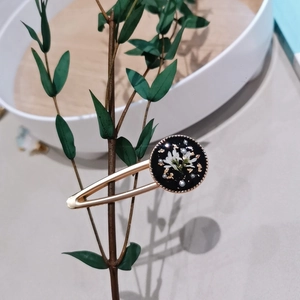 Handmade vintage hair clip with dried flowers and gold foil in a black resin setting