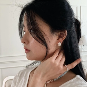 Model wearing organic silver petal earrings and light blue beaded necklace set