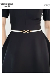 White slim leather belt with interlocking gold buckle detail on black dress
