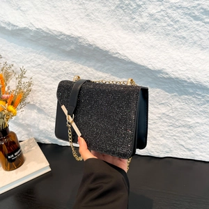 Chic black sequin crossbody bag with gold chain strap and stylish flap closure