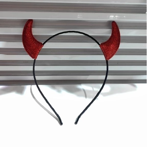 Close-up of red sequined devil horns on a slim black metal headband for Halloween