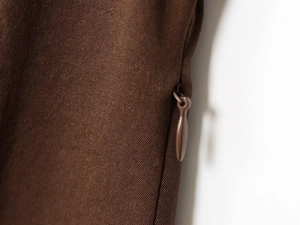 Détail du tissu en sergé marron café avec une fermeture éclair invisible de qualité