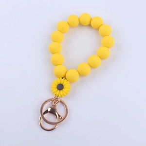 Close-up of yellow silicone beaded wristlet keychain with sunflower and gold clasp