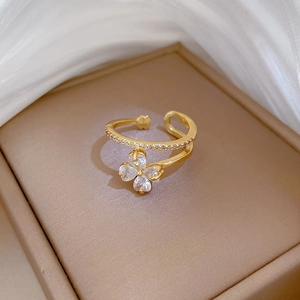 Adjustable gold flower ring with clover shaped diamonds on a warm jewelry box