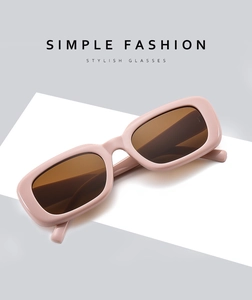 Detail of square sunglasses with stylish peach frames and brown tinted lenses