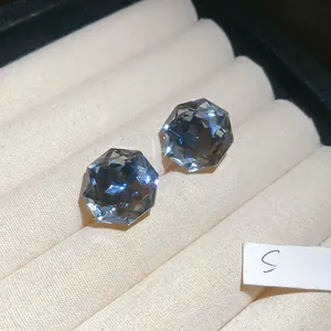 Macro shot of blue hexagonal cut gemstone studs placed in a beige velvet jewelry box