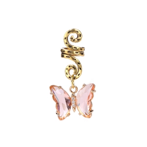 Détail du pendentif papillon en cristal rose sur l'accessoire de cheveux spirale doré