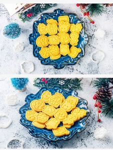 Close-up of golden Christmas cookies in Santa, reindeer and bell shapes with X'mas engraving